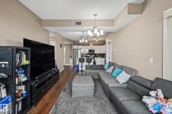 Open-concept living area with wood-finish flooring extending into the kitchen - 