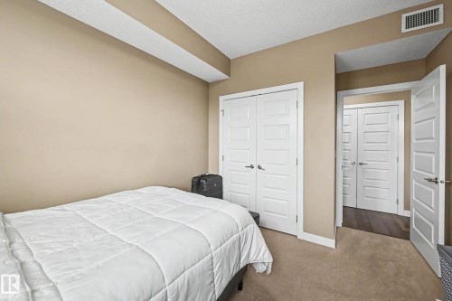 Bedroom featuring neutral-toned walls and carpet flooring - 402 8730 82 Avenue, Edmonton, AB 