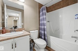Full bathroom featuring a single vanity with an integrated sink, a commode, and a tub-shower combination - 