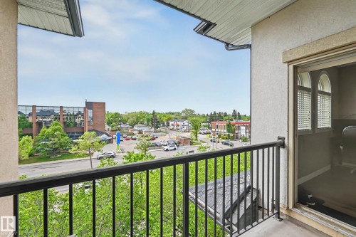 Balcony featuring a black metal railing and stucco exterior - 402 8730 82 Avenue, Edmonton, AB 
