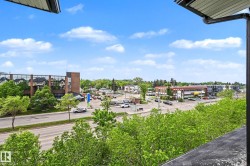 Urban landscape featuring a prominent commercial building with a glass facade and brick accents, surrounded by mature trees - 