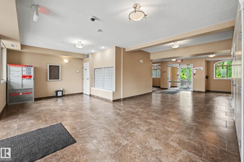 Building lobby featuring neutral-toned walls, recessed lighting, and large format tiled flooring - 402 8730 82 Avenue, Edmonton, AB 