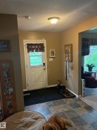 Entryway featuring durable tile flooring, a white exterior door with window, and a flush-mount ceiling light - 