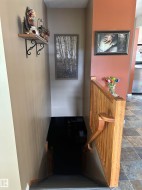 Stairwell featuring wood-finish handrails and a durable tile flooring entry - 