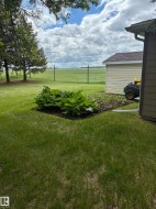 Green lawn with a planted garden bed - 