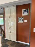 Full-height cabinetry with raised-panel doors and dark hardware - 