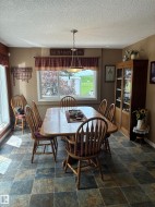 Dining area featuring a central window, pendant light fixture, and multi-toned square floor tiles - 
