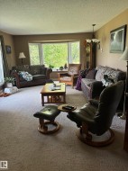 Spacious living area featuring a large bay window, neutral wall paint, and a textured ceiling - 