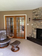 Corner fireplace featuring a stone surround and wood mantel - 