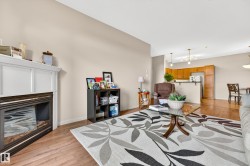 Living area featuring wood-finish flooring, a white mantel fireplace, and neutral wall tones - 