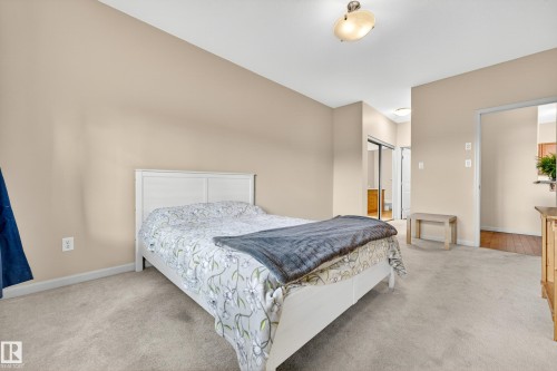 Carpeted room featuring neutral wall tones, a ceiling-mounted light fixture, and a built-in closet with sliding mirrored doors - 133 2503 Hanna Crescent, Edmonton, AB 