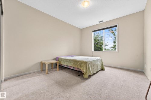 Room featuring neutral wall tones, light-colored carpeting, a large window, and a flush-mount ceiling light fixture - 133 2503 Hanna Crescent, Edmonton, AB 