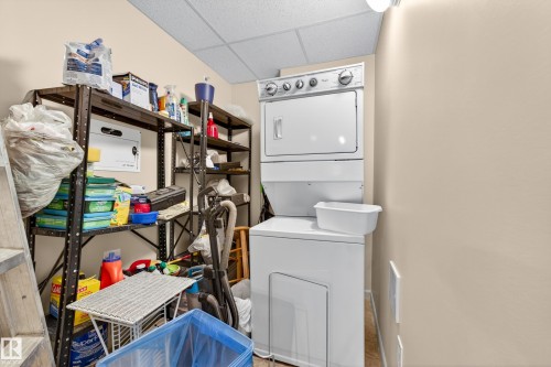 Compact laundry area featuring a stacked washer and dryer, neutral wall paint, and a drop ceiling - 133 2503 Hanna Crescent, Edmonton, AB 