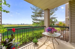 Expansive covered balcony featuring a concrete floor, black metal railing, and neutral-toned siding - 