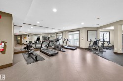 Fitness center with mirrored walls, multiple exercise machines, recessed lighting, and windows with blinds - 