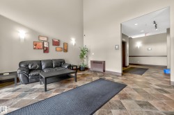 Lobby area featuring diamond-patterned floor tiling, wall sconces, and a high ceiling - 