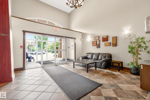 Spacious lobby featuring a vaulted ceiling and a decorative chandelier - 133 2503 Hanna Crescent, Edmonton, AB 