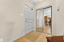 Foyer entryway featuring a white paneled door, mirrored closet doors, and tile flooring - 