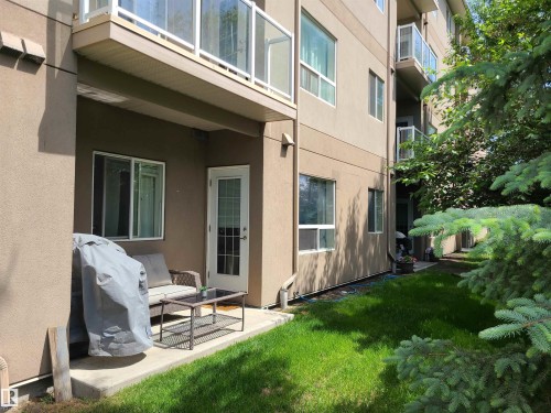 Ground-level patio with a concrete slab, access door, and sliding window - 116 5005 165 Avenue, Edmonton, AB 