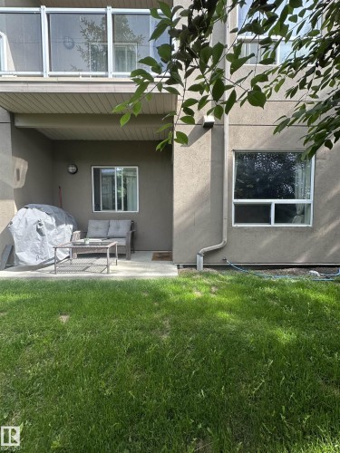 Multi-story residential building featuring a light-toned stucco exterior with contrasting dark shingled roofs - 116 5005 165 Avenue, Edmonton, AB 