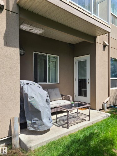 Private concrete patio bordered by green lawn - 116 5005 165 Avenue, Edmonton, AB 