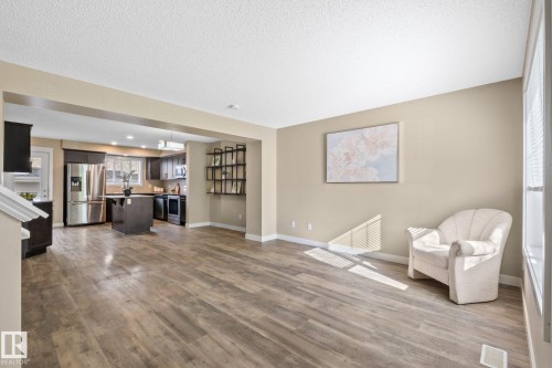 Open-concept living space featuring wood-finish flooring, recessed lighting, and neutral wall tones - 12809 203A, Edmonton, AB 