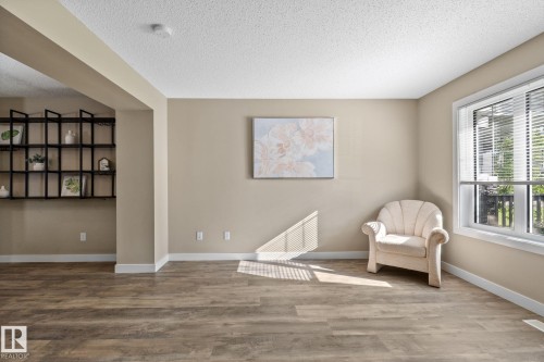 Light-filled interior space featuring wood-finish flooring, neutral wall tones, and white trim - 12809 203A, Edmonton, AB 