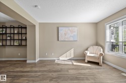 Light-filled interior space featuring wood-finish flooring, neutral wall tones, and white trim - 