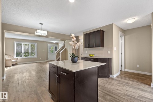 Kitchen island with light-toned countertop and dark wood-finish cabinetry - 12809 203A, Edmonton, AB 