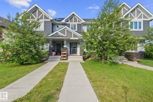 Duplex exterior featuring gray siding, white trim, and stone accents - 12809 203A, Edmonton, AB 