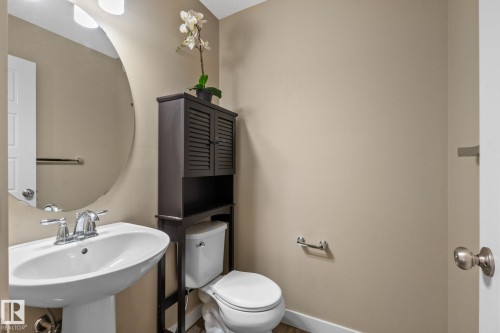 Pedestal sink with chrome faucet, oval wall mirror, and overhead vanity lighting - 12809 203A, Edmonton, AB 
