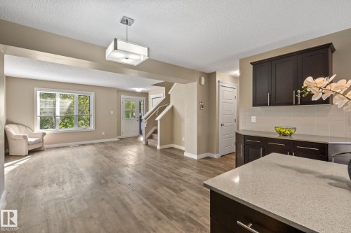 Open-concept living space featuring wood-finish flooring and neutral paint tones - 12809 203A, Edmonton, AB 