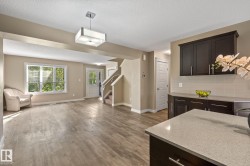 Open-concept living space featuring wood-finish flooring and neutral paint tones - 