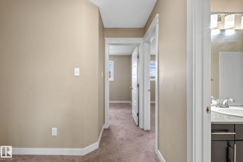Hallway with neutral wall tones and brown carpeted flooring - 12809 203A, Edmonton, AB 