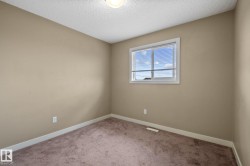 Room with neutral tone walls, brown carpeting, and white baseboards - 