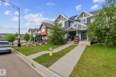 Two-story townhome featuring a grey siding and stone facade with white trim accents - 12809 203A, Edmonton, AB 