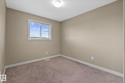 Neutral-toned room featuring a single window with blinds, light tan walls, and brown carpet flooring - 12809 203A, Edmonton, AB 