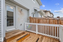 Outdoor deck featuring wood plank flooring, white railing, two-step entry, a glass-paneled exterior door, and a privacy fence - 