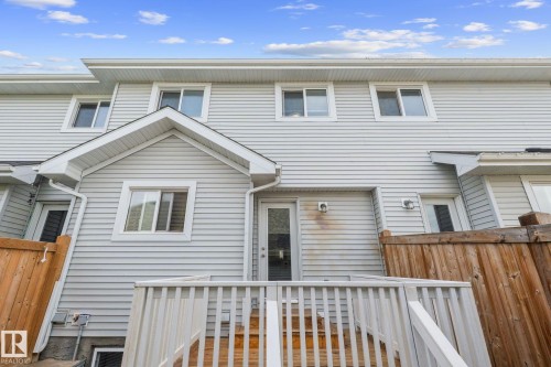 Rear exterior featuring light-colored siding and multiple windows - 12809 203A, Edmonton, AB 
