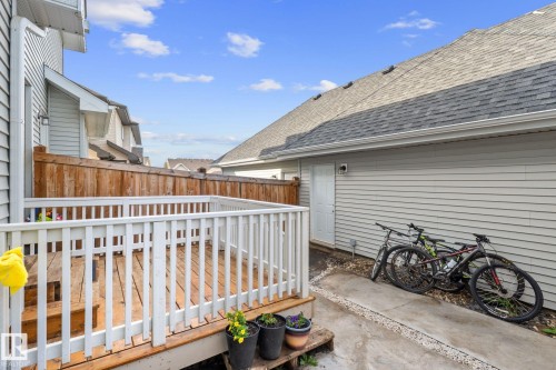 Wood deck with white railing, privacy fence, and concrete patio area - 12809 203A, Edmonton, AB 