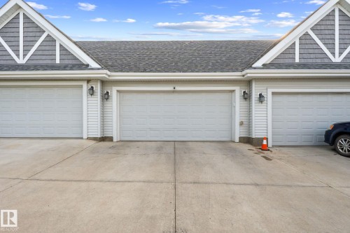 Three garage doors with paneling, shingle roofing, and decorative gables - 12809 203A, Edmonton, AB 