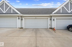 Three garage doors with paneling, shingle roofing, and decorative gables - 