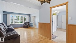 Living area featuring wood-finish flooring, a large bay window, and light blue wall paint - 