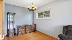 Room featuring light wood-finish flooring, a white-framed window, and a ceiling-mounted chandelier - 