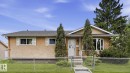 Bungalow-style residence featuring stucco exterior, a gabled entry, and a chain-link fence - 13008 105 Street Nw, Edmonton, AB 
