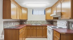 U-shaped kitchen featuring wood cabinetry, laminate countertops, a tile backsplash, and a double basin sink - 