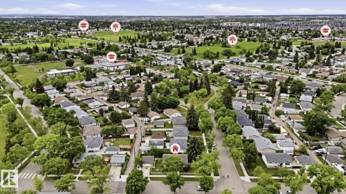 Expansive aerial perspective showcasing a residential neighborhood with numerous detached homes, mature trees, and green spaces - 13008 105 Street Nw, Edmonton, AB 