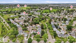 Expansive aerial perspective showcasing a residential neighborhood with numerous detached homes, mature trees, and green spaces - 