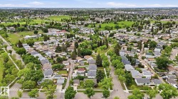 Aerial depiction of a residential area with extensive green spaces and mature tree canopies - 