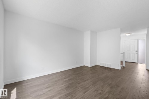Open concept room featuring wood-finish flooring, white baseboards, and neutral wall tones - 2832 135 Avenue, Edmonton, AB - Indoor Photo Showing Other Room